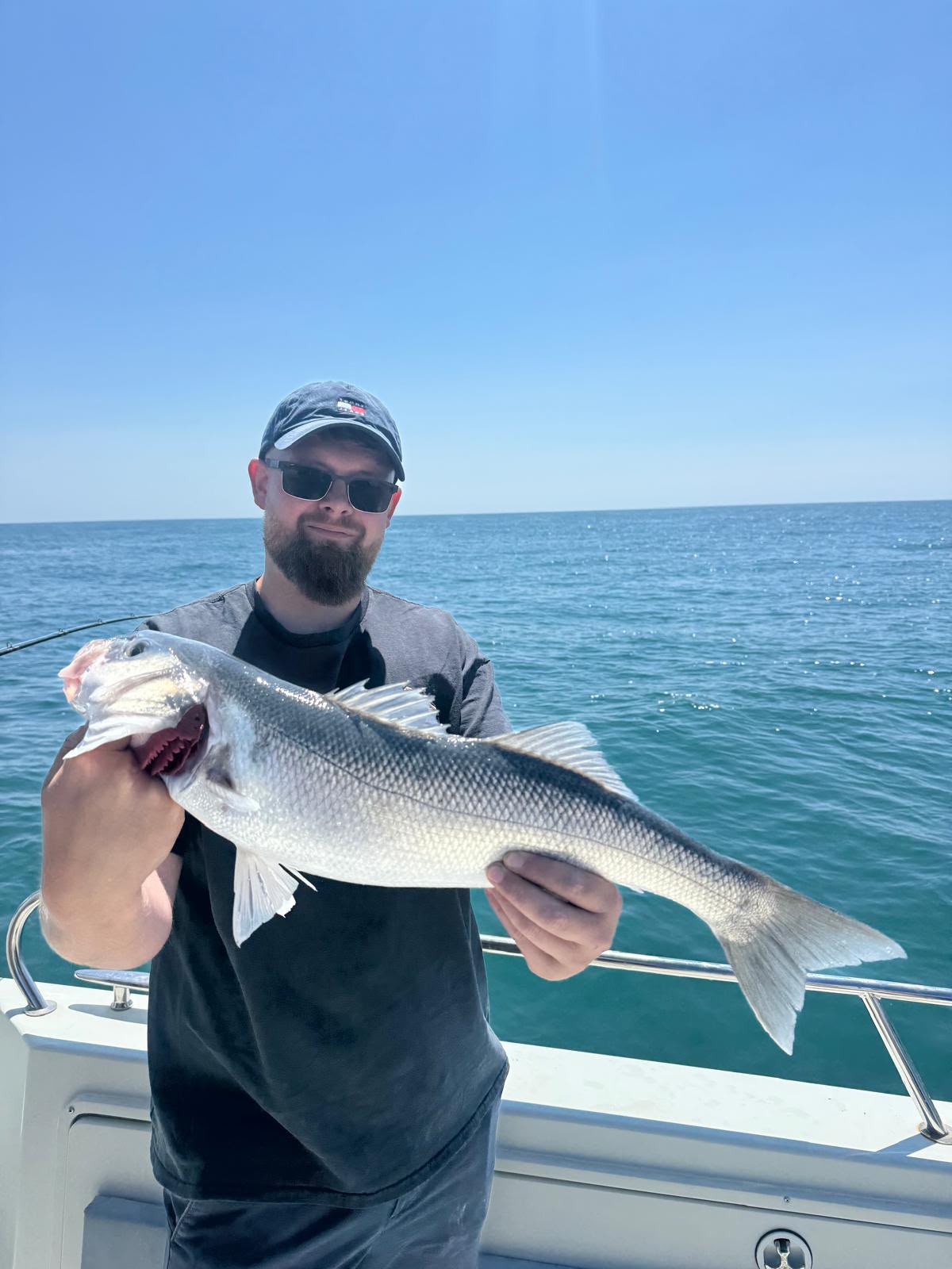 Angler holding a large silver fish beside the boat rail