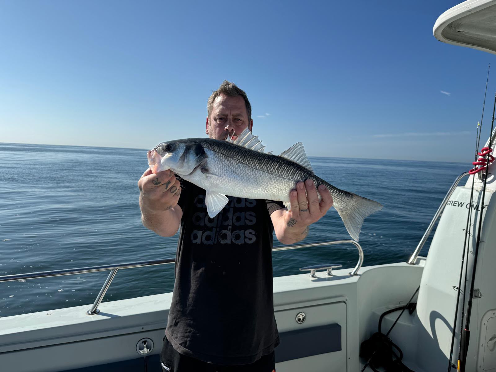 Angler holding a fish beside the cabin
