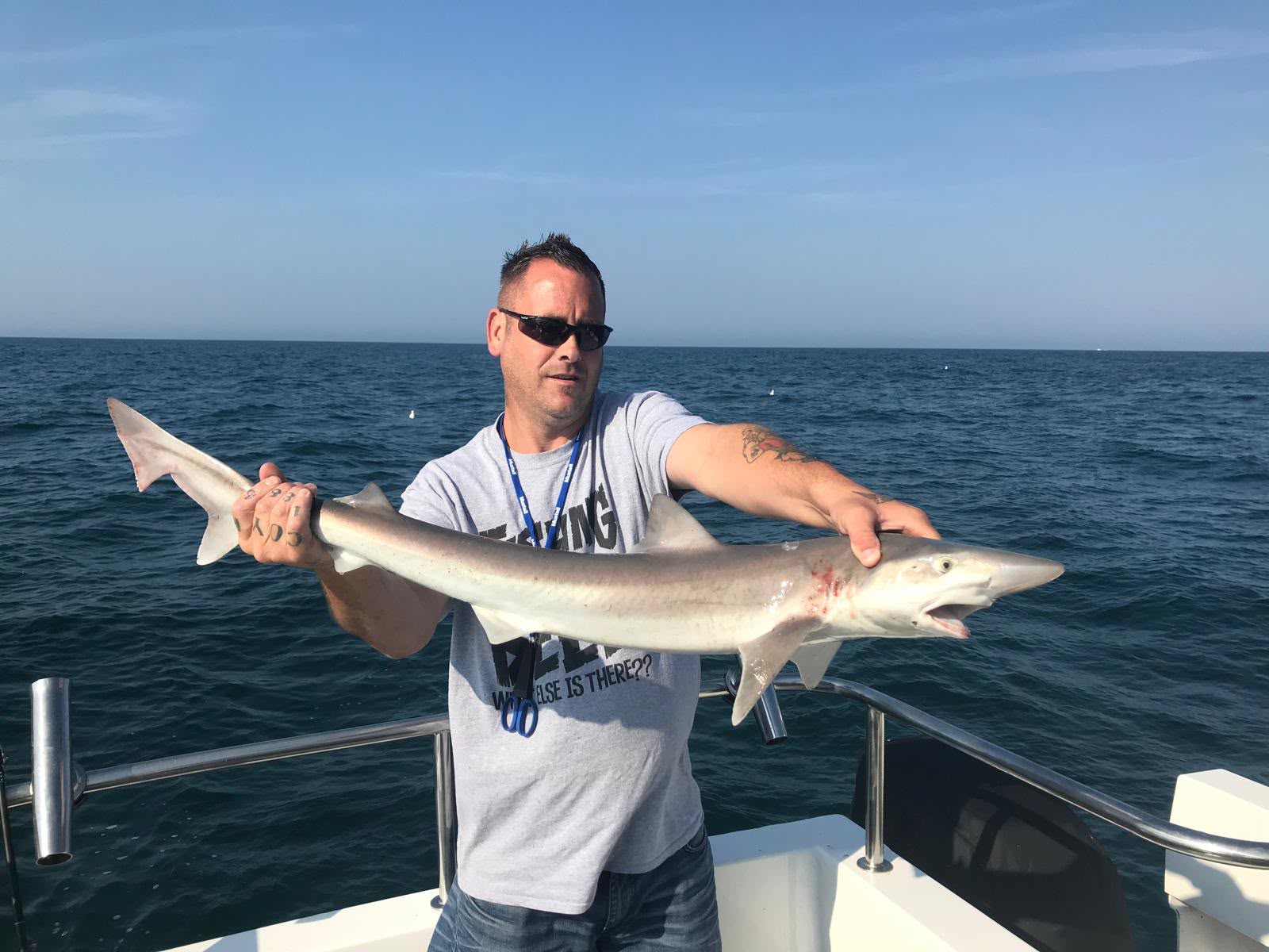 Angler displaying a shark at sea