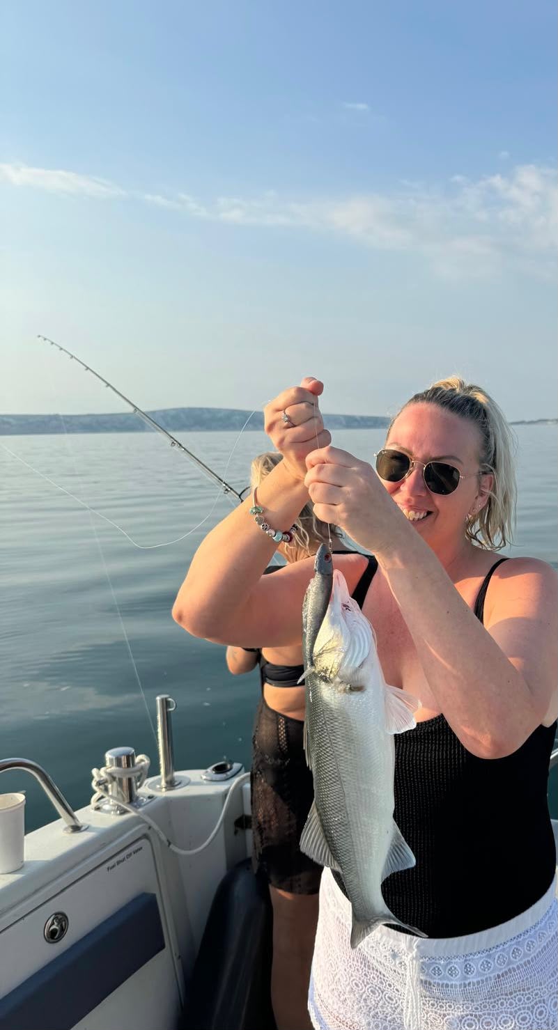 Angler lifting a catch from the line aboard Raptor