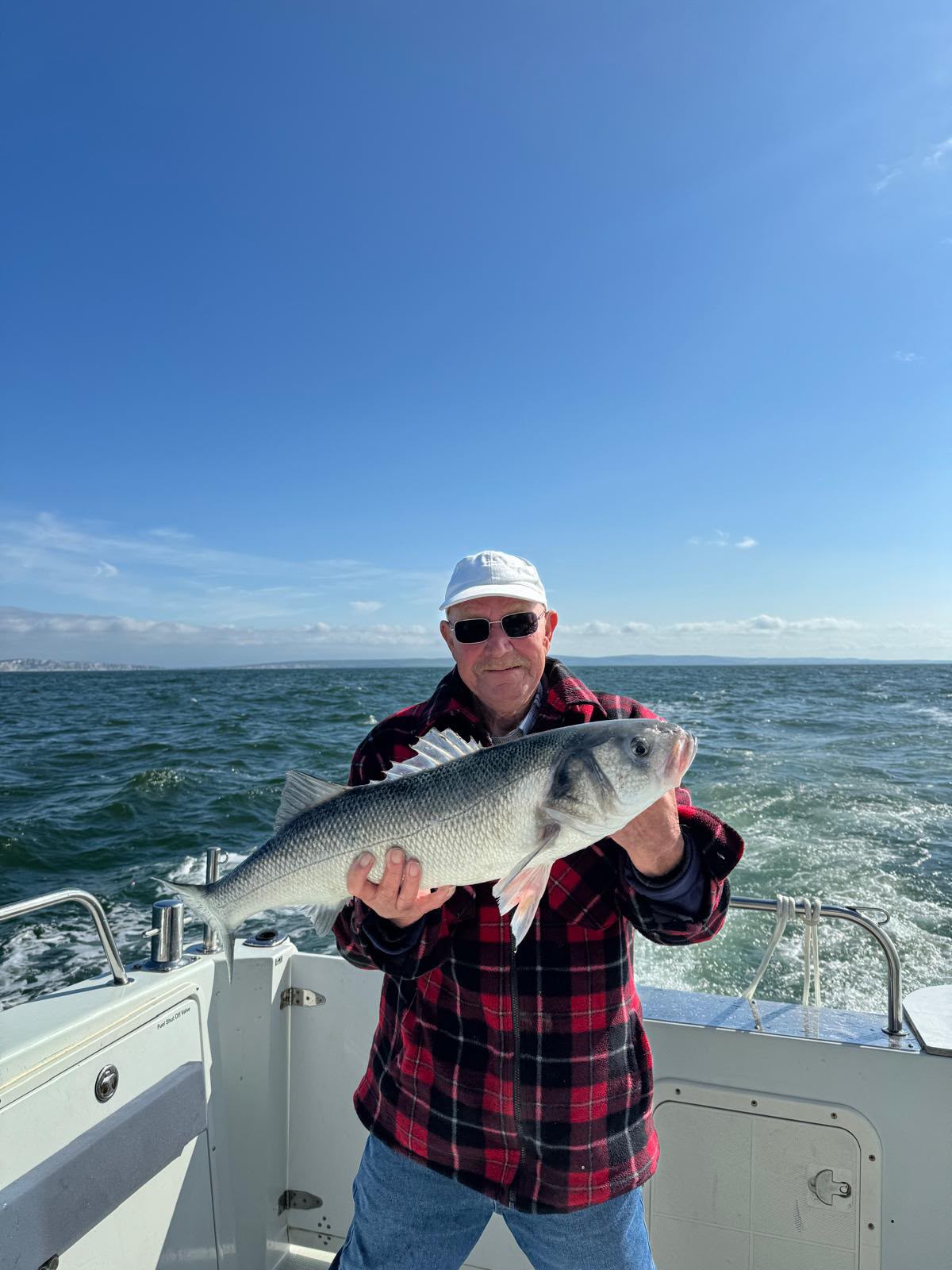 Angler holding a fish on the aft deck