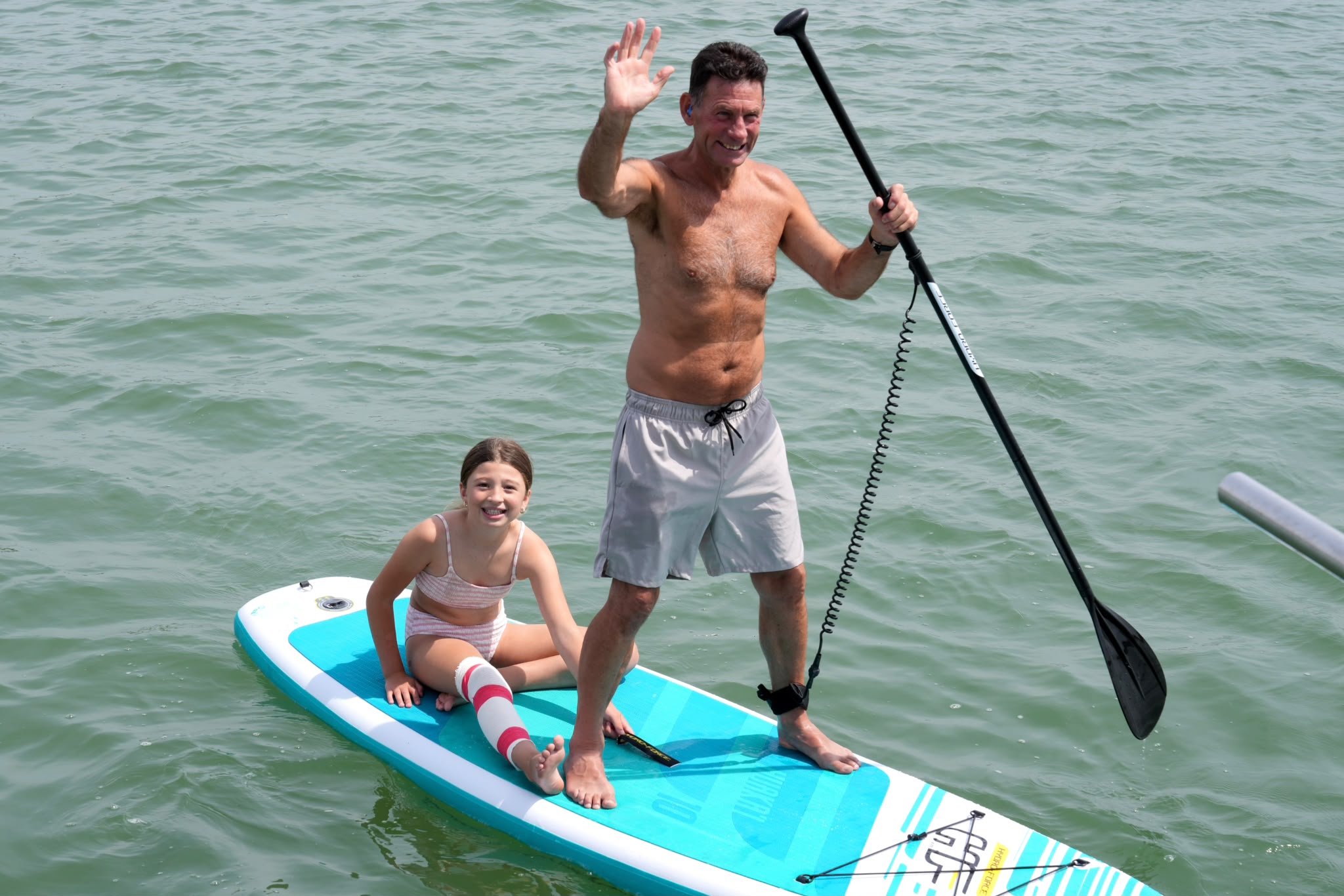 Guests waving from a paddleboard