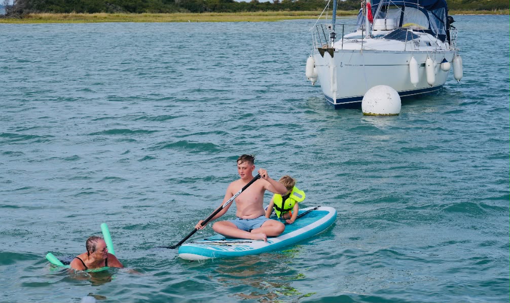 Paddleboarding beside an anchored yacht