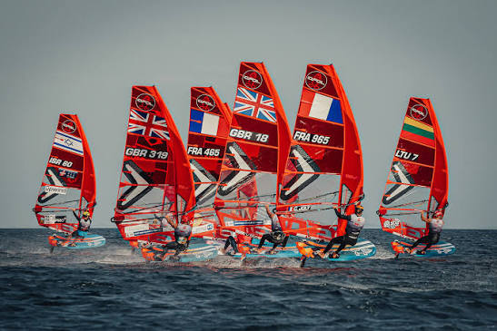 iQFOiL windsurfers racing together at sea with brightly coloured sails